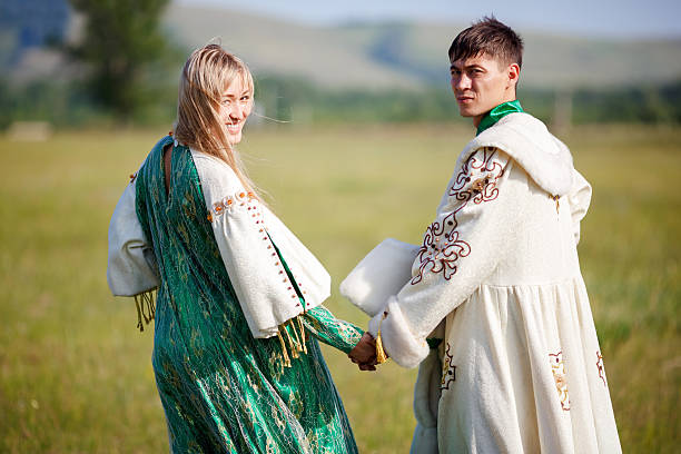 istock Couple in ethnic costumes hold hands turned back to  camera 519762034