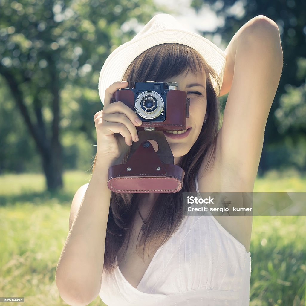 Young woman posing with old film camera in summer park Young beautiful woman posing with old film camera in summer park. Toned image. 20-29 Years Stock Photo