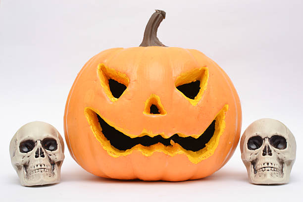 istock Halloween pumpkin and skull in a fireplace 519763455