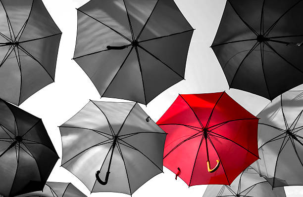 istock red umbrella standing out from the crowd 519764619