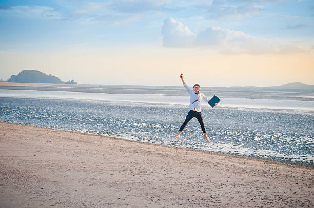 istock Business man working with laptop and smartphone beach background 519778380