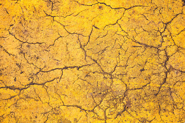 istock background of yellow textured surfaces with cracks 519782032