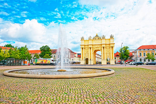 Street view on Brandenburg Gate and fountain in Potsdam Street view on Brandenburg Gate and fountain in Potsdam in Germany. It is placed on Luisenplatz. Tourists nearby potsdam brandenburg stock pictures, royalty-free photos & images