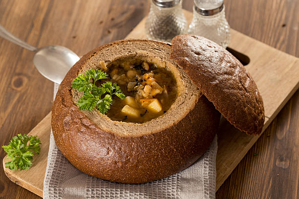 istock Fresh pea soup in bread bowl on a wooden desck 519785002