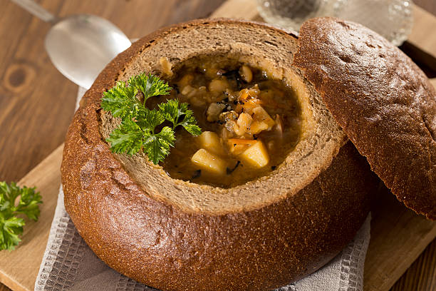 istock Fresh pea soup in bread bowl on a wooden desck 519785068
