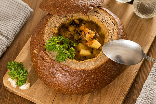 istock Fresh pea soup in bread bowl on a wooden desck 519785534