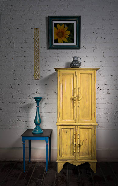 istock Vintage yellow cupboard, framed painting, blue candlestick and small table 519786326