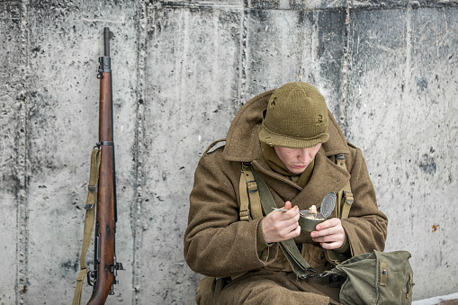 Stock photo of a soldier eatting a canned ration.