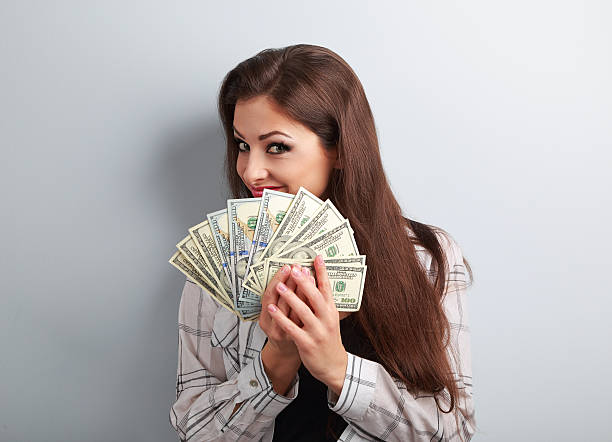 istock Happy successful young pretty woman holding dollars in hands 519789034