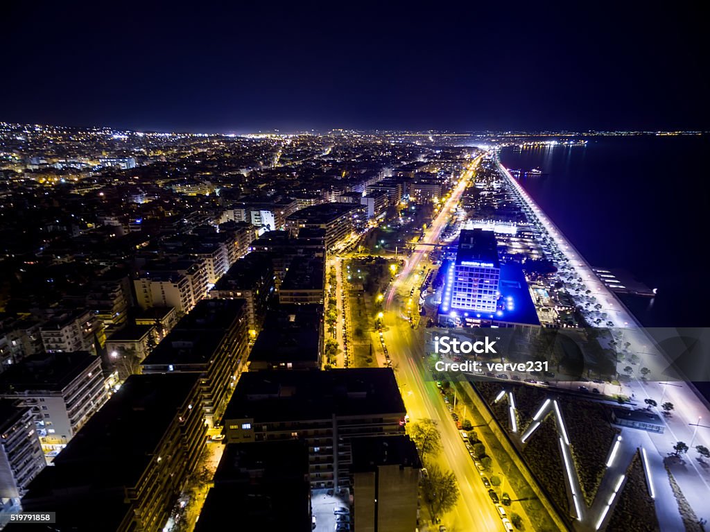 Aerial view of city Thessaloniki at night, Greece. Aerial view of city Thessaloniki at night, Greece.. Image taken with action drone camera causing distortion and blur. Above Stock Photo