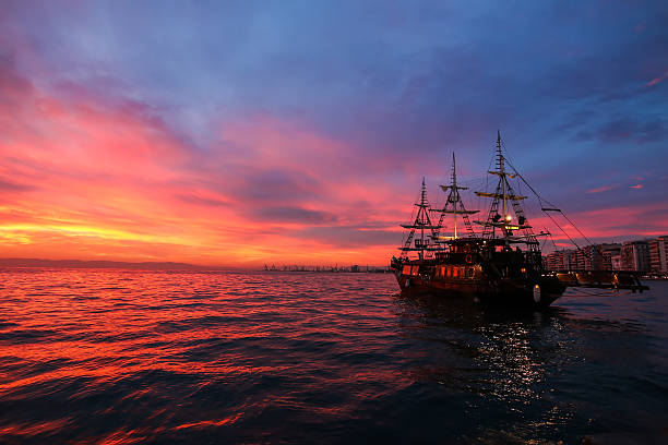 Silhouette an antique ship at a beautiful sunset.