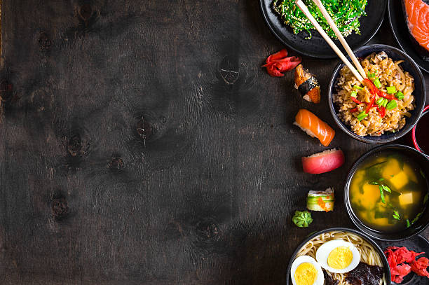 comida japonesa sushi y sobre un fondo oscuro - comida asiática fotografías e imágenes de stock