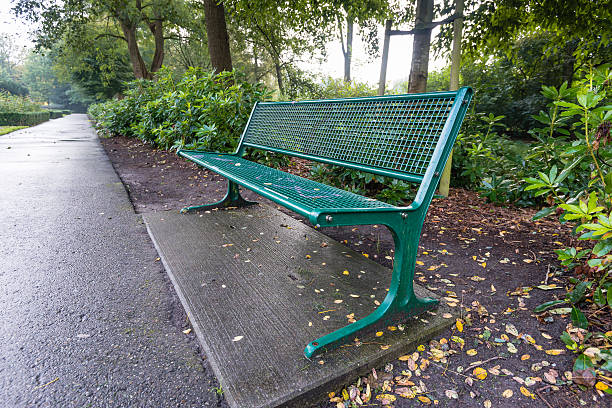 istock Green metal bench in a park 519803159