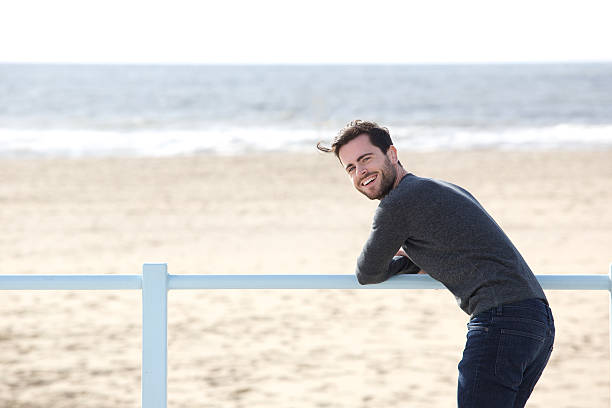 istock Happy man standing alone at the beach 519804273
