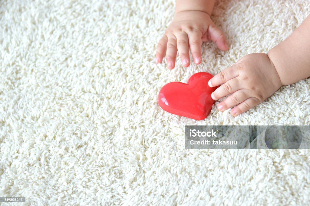 Bebé de la mano con herat juguete - Foto de stock de Alumbramiento libre de derechos