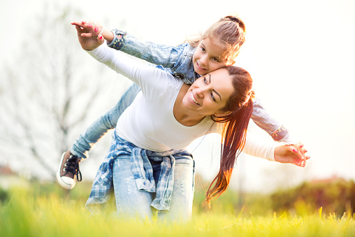 Mother with her cute little daughter relaxing together outdoor.