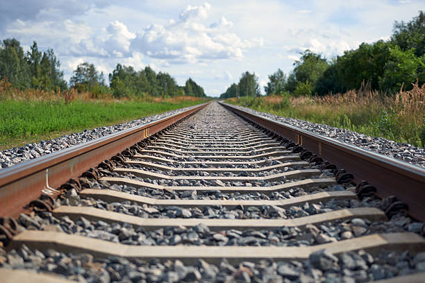 Landscape with railroad to horizon and blue sky with clouds stock photo