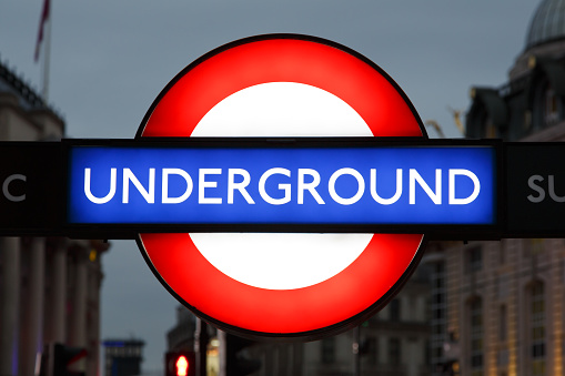 London, UK - September 25, 2014: A London Underground famous sign at night in London. It is called The Tube or The Underground and 