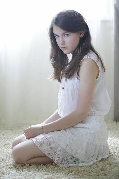 Young beautiful girl sitting on the floor stock photo