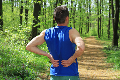 Back pain. Man Runner lower back pain injury