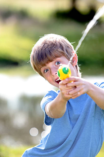 istock Young boy firing a water pistol 519836148