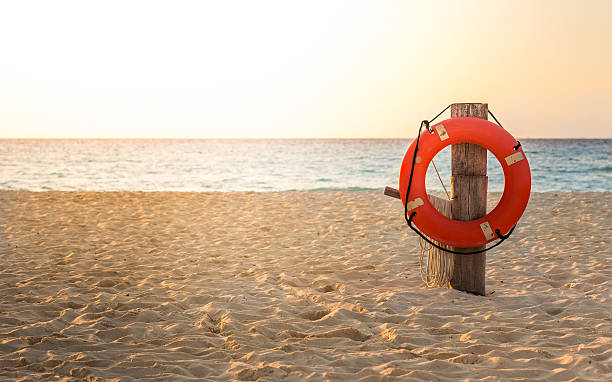 Life preserver on sandy beach stock photo