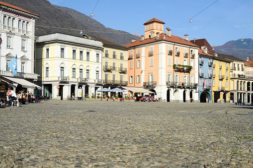 Locano, Switzerland- October 19, 2014: tourists walking and sitting in the middle of old houses on Piazza grande square at Locarno on the italian part of Switzerland