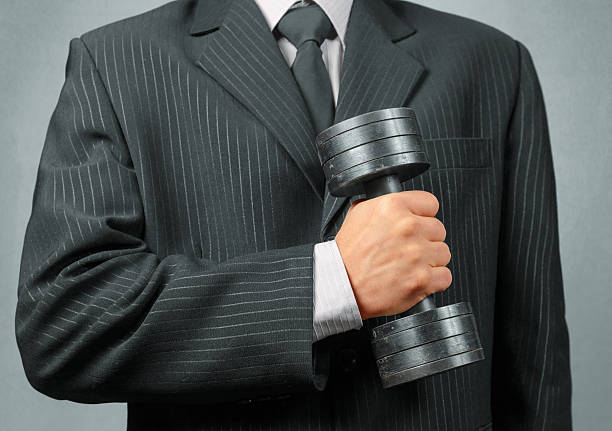 istock Businessman holds metal dumbbell 519847807