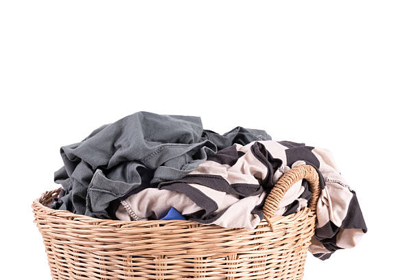 istock Clothes in a laundry wooden basket isolated on white background 519861689