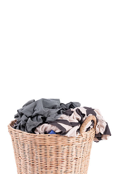 istock Clothes in a laundry wooden basket isolated on white background 519861691