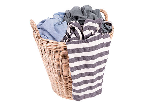 istock Clothes in a laundry wooden basket isolated on white background 519861699