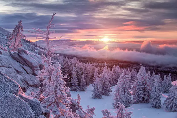 Landscape with purple colors, mountains, forest and snowfield. South Ural, Russia