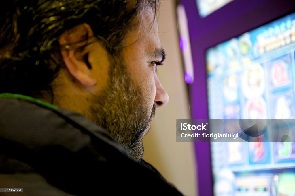 man play front to the slot man player watch the monitor of slot machine Adult Stock Photo