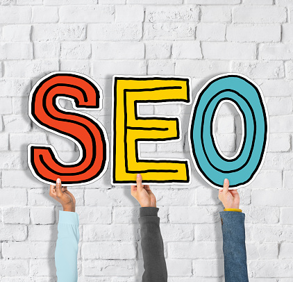 Diverse Group of Hands Holding Word SEO