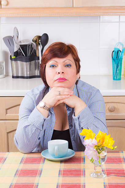 istock Middle aged woman with headache in kitchen 519863264