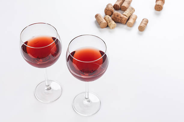 Glass of red wine and corks isolated on white background. stock photo