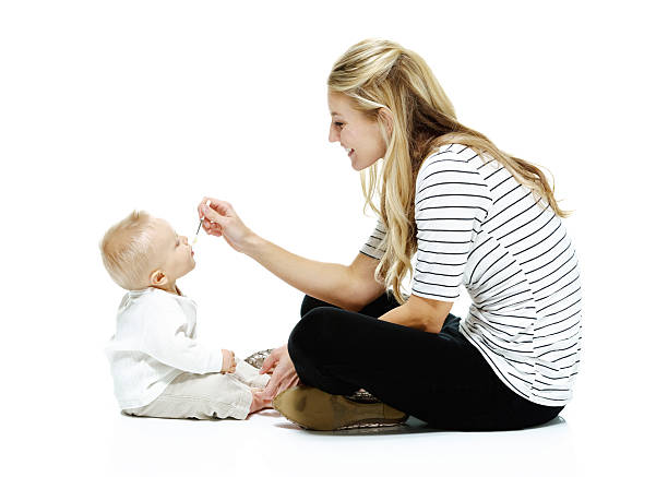 istock Smiling mother feeding her baby 519864284
