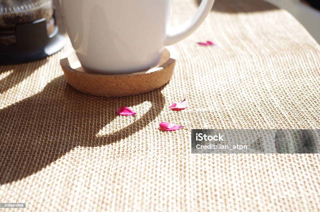 Morning Coffee with Petals White Coffee cup on table with pink petals Aromatherapy Stock Photo