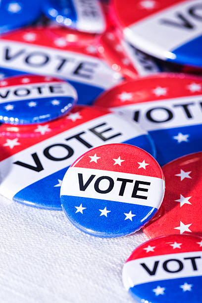 istock Various size Patriotic VOTE buttons on white table cloth 519866090