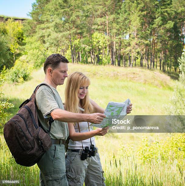 Tourists Examining Map While Standing In Nature Happy Hiking Couple Stock Photo - Download Image Now