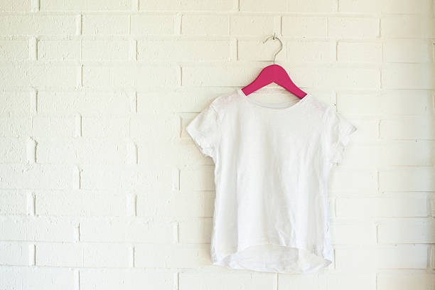 White tshirt hanging on a pink hanger stock photo