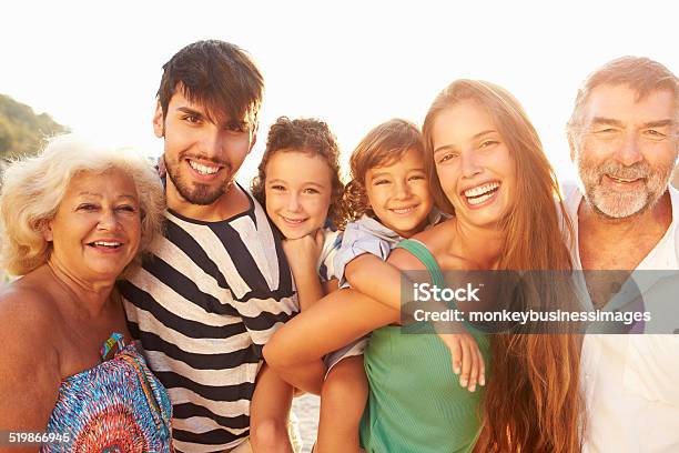 Multi Generation Family Giving Children Piggybacks On Holiday Stock Photo - Download Image Now