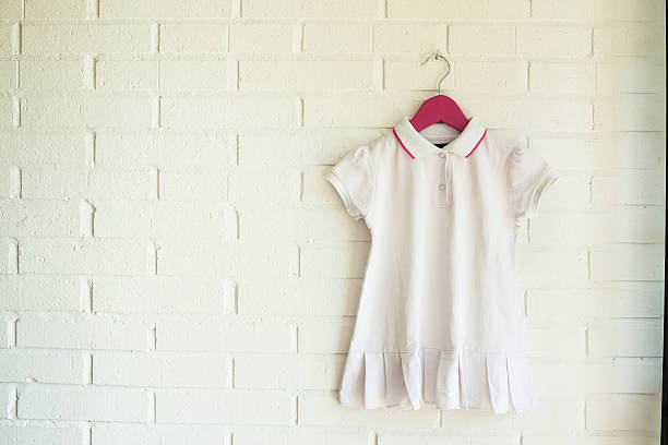 White dress hanging on a pink hanger stock photo