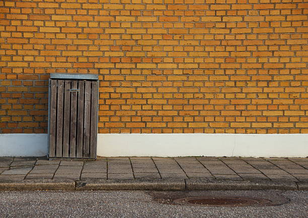 istock Outdoor Garbage Can with Yellow Brick Wall Background 519867276