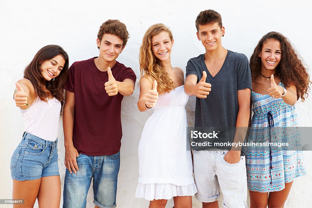 Teenage Group Leaning Against Wall Giving Thumbs Up Teenage Group Leaning Against Wall Giving Thumbs Up  Smiling To Camera Group Of People Stock Photo