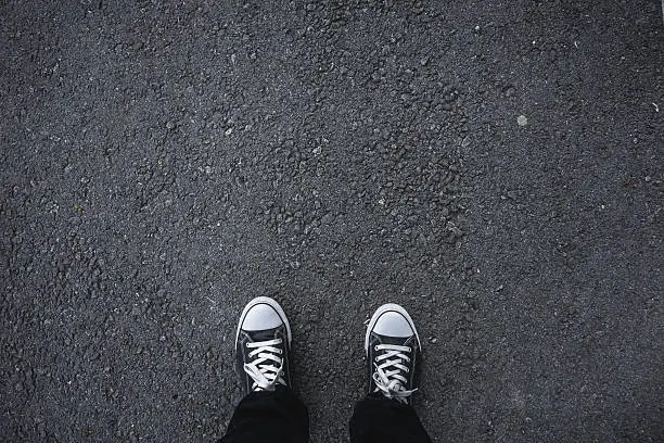 Photo of Canvas shoes on asphalt