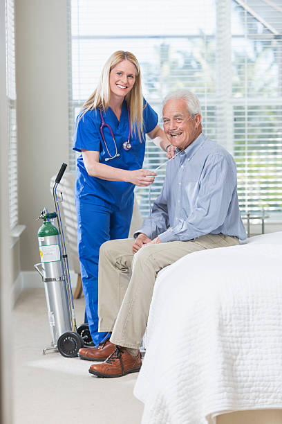 istock Home healthcare nurse helping elderly man with oxygen 519872962