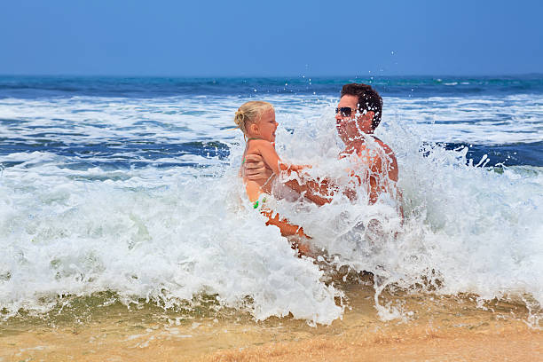 istock Man with child playing with fun on sand sea beach 519873574