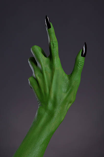 green hexe hand mit schwarzen nägeln, real body-art - green monster stock-fotos und bilder