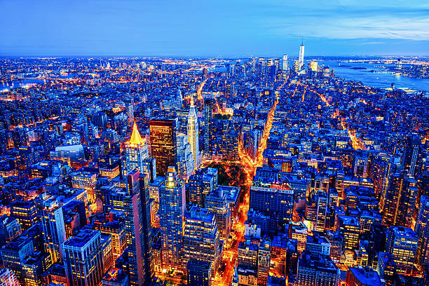 midtown e menor horizonte de manhattan, nova york, eua - night empire state building building exterior horizontal - fotografias e filmes do acervo